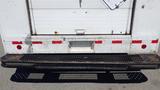 A rear view of a 2006 Ford Econoline showing the bumper and heavily worn loading dock step with a textured surface and visible rust marks