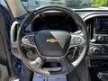 A 2021 Chevrolet Colorado's steering wheel with control buttons and the Chevrolet logo prominently displayed in the center