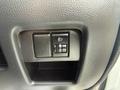 A close-up of the control panel in a 2009 Suzuki Carry featuring two buttons for headlights and fog lights with a textured black surface