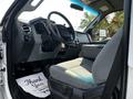Interior of a 2016 Ford F-550 featuring a steering wheel and driver seat with gray upholstery and a floor mat that says Thank You