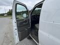 A 2014 GMC Savana van with the driver's side door open showing the interior and steering wheel
