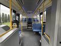 Interior of a 2016 Grande West Vicinity bus showing blue fabric seats and yellow handrails with an empty aisle leading to the front of the bus