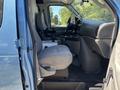 A 2008 Ford E-350 interior featuring a driver’s seat and a gray upholstery with a console and cup holders visible