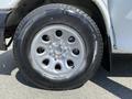 A close-up of a silver wheel with eight spokes and a black Michelin tire on a 2009 Chevrolet Express