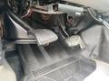 Close-up of the foot pedals in a 2003 Ford F-450 SD showing the brake and accelerator pedals with a textured rubber mat beneath them
