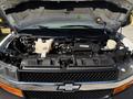 A 2017 Chevrolet Express with its hood open revealing the engine and various components inside the engine bay