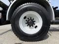 A close-up of a white wheel from a 2016 Freightliner 108SD featuring a Michelin tire with a detailed tread pattern and black lug nuts