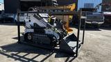 A 2024 Power JQ 400 compact tracked loader with a bucket attachment sitting on a transport rack