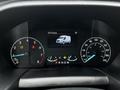 Dashboard display of a 2023 Ford Transit showing speedometer odometer and warning lights with a graphic of the van in the center