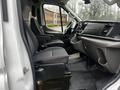 Interior of a 2021 Ford Transit showing driver and passenger seats with a dashboard and infotainment system