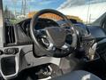 The interior of a 2017 Ford Transit showing the steering wheel dashboard and controls