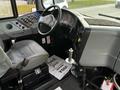 Interior view of a 2013 International 4200 featuring a steering wheel dashboard with various controls and a driver's seat with a thank you note on the floor