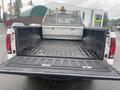 A 2005 Ford F-350 SD with an open truck bed showing a metal tool box and a lined interior