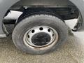 A close-up view of a wheel and tire of a 2018 Ford Transit showing the tire tread and silver rim with several black holes