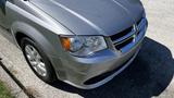 A silver 2016 Dodge Grand Caravan with a prominent front grille and headlights visible from an angled view