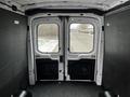 Interior view of the back doors of a 2021 Ford Transit van with a spacious cargo area and gray walls