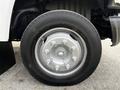 Close-up of a silver wheel and tire from a 2006 GMC C5000 with visible lug nuts and branding on the tire sidewall