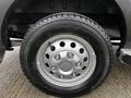 Close-up view of a silver wheel on a 2023 Ford Transit featuring multiple bolts and a textured tire tread