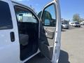A 2012 Chevrolet Express van with the driver's side door open, revealing a gray interior and dashboard details.