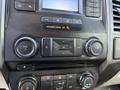 Dashboard controls of a 2018 Ford F-150 featuring audio system buttons and climate control dials