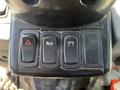 Control panel of a 2018 New Holland Boomer 45 featuring three buttons for hazard lights a warning light and a one related to engine functions