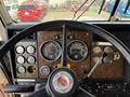 The image shows the dashboard of a 1996 Kenworth T800 featuring gauges for speed, fuel, and oil along with a steering wheel and various control buttons and levers