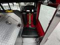 Interior view of a 1991 Sutphen Deluge fire truck showcasing a black leather seat with safety straps and a metal storage compartment nearby