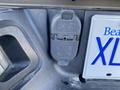 A close-up of a 2017 RAM 1500 trailer hitch wiring connector mounted on the vehicle's body showcasing the socket design with labels and a protective cover