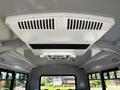 The interior ceiling of a Chevrolet Express featuring a white air conditioning unit with vents and a smooth surface