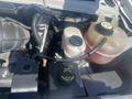 A 2009 Ford Econoline engine's interior featuring various components such as fluid reservoirs wiring and a black plastic cover