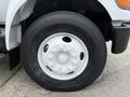 A close-up of a tire on a 2004 Ford F-750 featuring a white rim and Michelin branding on the tire sidewall
