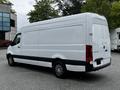 A 2019 Mercedes-Benz Sprinter van with a white exterior and black accents, viewed from the rear and side, showcasing its cargo capacity and sleek design