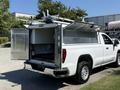 A 2022 GMC Sierra 1500 with an open truck bed featuring a white canopy and equipment mounted on top