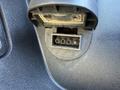 A close-up of a black plastic connector with four metal pins inside a rectangular socket on a vehicle dashboard