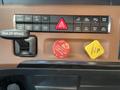 Close-up of the dashboard controls in a 2022 Freightliner Cascadia featuring various buttons and switches for functions like trailer brake parking and hazard lights