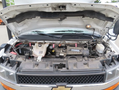 The engine compartment of a 2020 Chevrolet Express showing various components including the battery coolant reservoir and air intake system