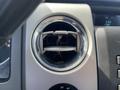 The image shows a circular air vent from a 2012 Ford F-150 with a silver rim and adjustable slats in the center