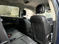 Interior view of a 2013 Dodge Journey featuring two black leather seats in the foreground with headrests and a central console