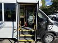 A 2017 Ford Transit with open double doors revealing steps and driver seat inside