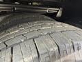 Close-up of two worn tires of a 2010 Ford Econoline showing the tread pattern and wear on the surface