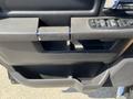 Close-up of the driver's door handle and control panel of a 2011 RAM 1500 featuring window and lock buttons in a textured black finish
