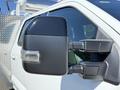 Close-up of the side mirror of a 2024 Ford F-550 Super Duty truck featuring a sleek black design with integrated lighting