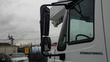 A 2005 International 4300 truck with a white body and large side mirrors, reflecting rain on the glass surface