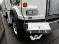 A 2011 Western Star Trucks 4900 with prominent headlights and a diamond-plate front bumper featuring a large W logo