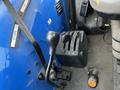 Control levers and knobs of a 2007 New Holland TN70A tractor with a blue panel and black components