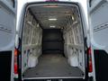 Interior view of a 2019 Mercedes-Benz Sprinter cargo van with open rear doors showing the empty cargo area and walls designed for maximum storage space