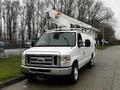 A white 2009 Ford Econoline van equipped with a raised aerial work platform mounted on the roof