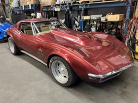 A 1970 Chevrolet Corvette in maroon color with a sleek design and distinctive features including wide tires and a stylish exterior