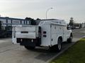 A white 2016 Ford F-350 SD pickup truck with a utility bed and a TOMMY GATE liftgate on the rear