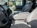 Interior view of a 2013 Ford F-250 SD showing the front seats and a center console with armrest and storage compartment